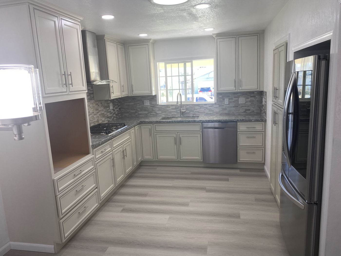 Cream cabinets, granite counters and mosaic backsplash