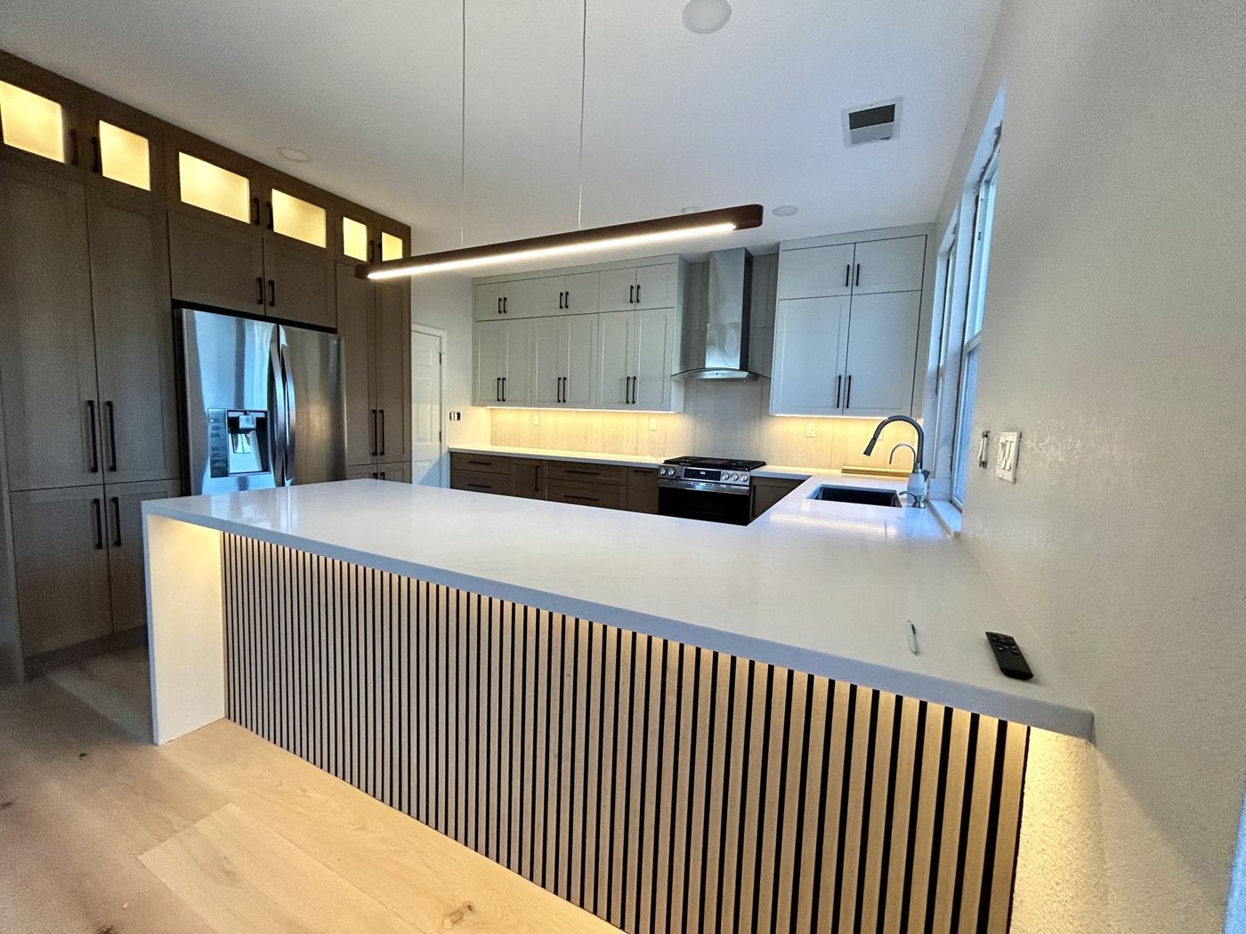 Kitchen island with oak slat panels and LED lighting